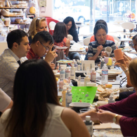Employees painting ceramics at a team building event hosted at Petroglyph.