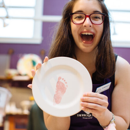 Happy woman and the ceramics she created at baby shower hosted at Petroglyph.